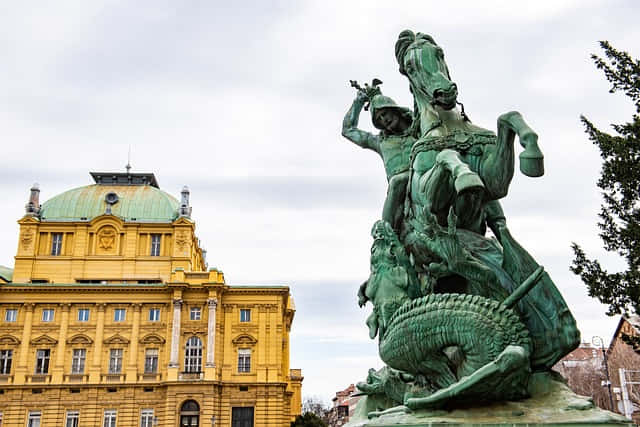 A statue and a building behind in Zagreb