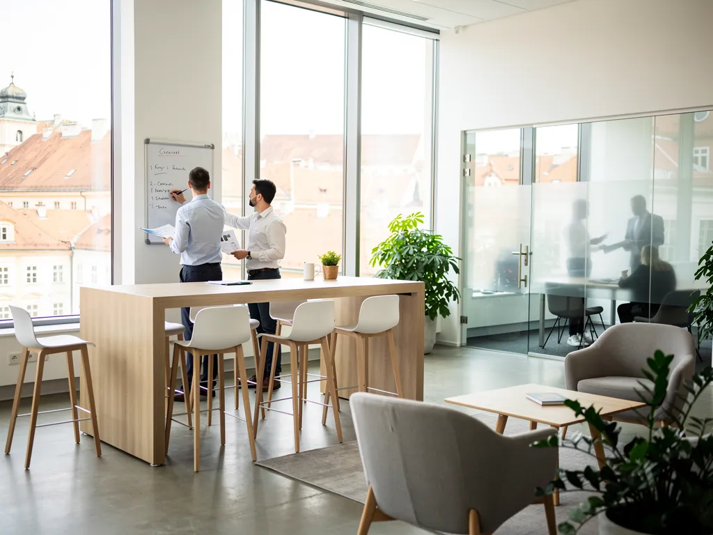 Two business professionals discussing a whiteboard list in a modern coworking office space in Zagreb